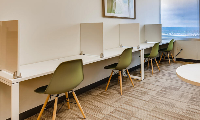 Office Evolution franchising coworking space with individual workstations and privacy panels, showcasing professional environments for entrepreneurs and remote workers.