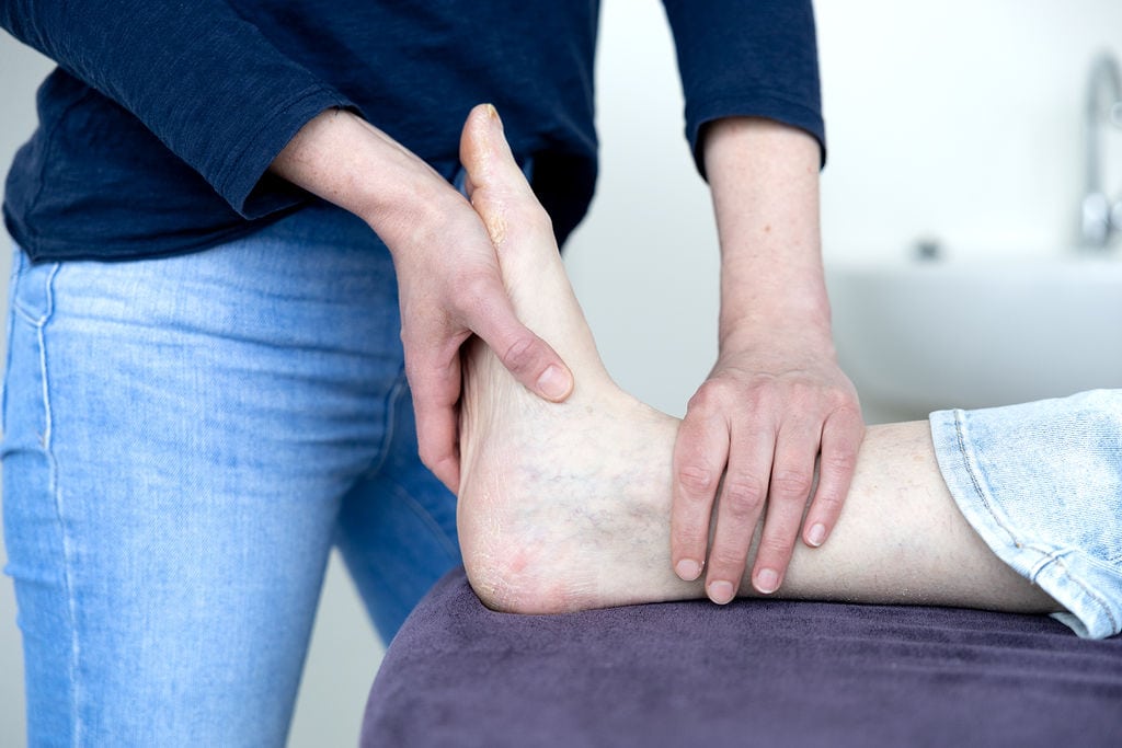 Fysiotherapeut behandelt voet- en hielpijn bij patiënt — Fysiotherapie Dunant Roosendaal