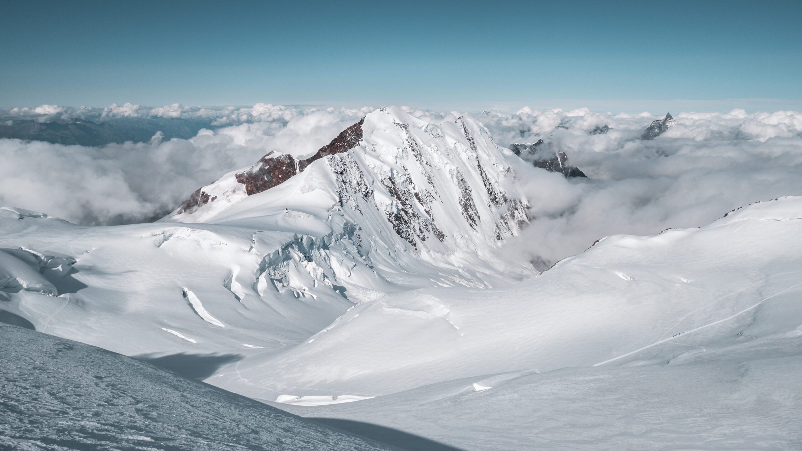 Lyskamm at 4527 meters showing the Menschenfresser famous snow ridge traverse between East and West summits in the Monte Rosa massif Pennine Alps Switzerland Italy border during 2026 climbing season with corniced ridges visible
