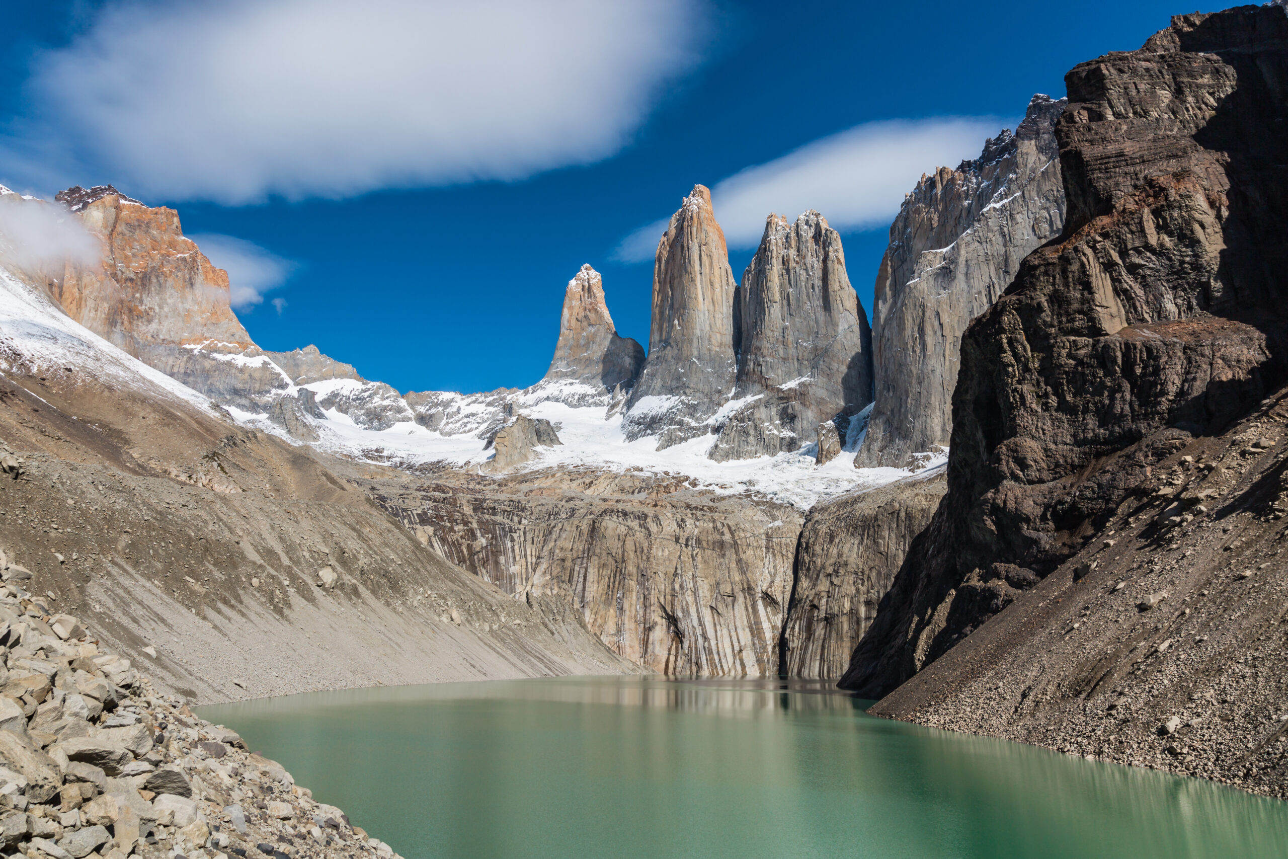 The three iconic granite Towers of Paine in Torres del Paine National Park Chilean Patagonia showing the dramatic vertical granite walls of Torre Sur 2,850 meters Torre Central 2,800 meters and Torre Norte 2,260 meters as the signature geological feature of the Paine Massif a 12 million year old granite intrusion that forced its way upward through softer sedimentary rock with Pleistocene glaciation since then eroding the surrounding sediment to expose the granite cores producing the characteristic dramatic vertical walls of the Torres the defining geological expression of the 242,242 hectare park and the most photographed feature of any national park in Chile demonstrating the dramatic tectonic and glacial history that shaped Chilean Patagonia