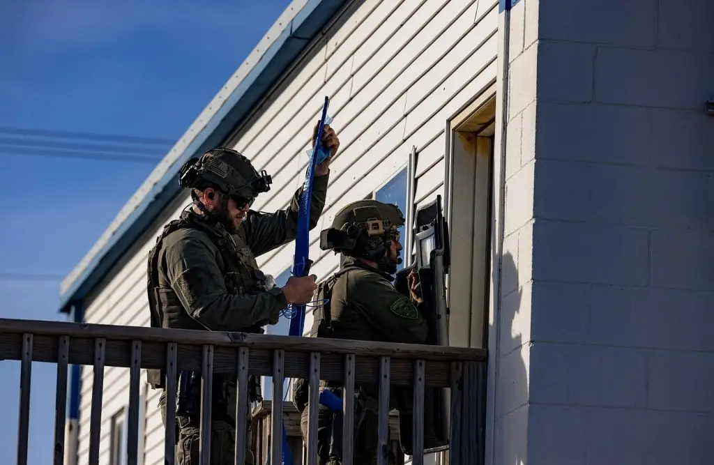 two officers standing at front door placing a charge