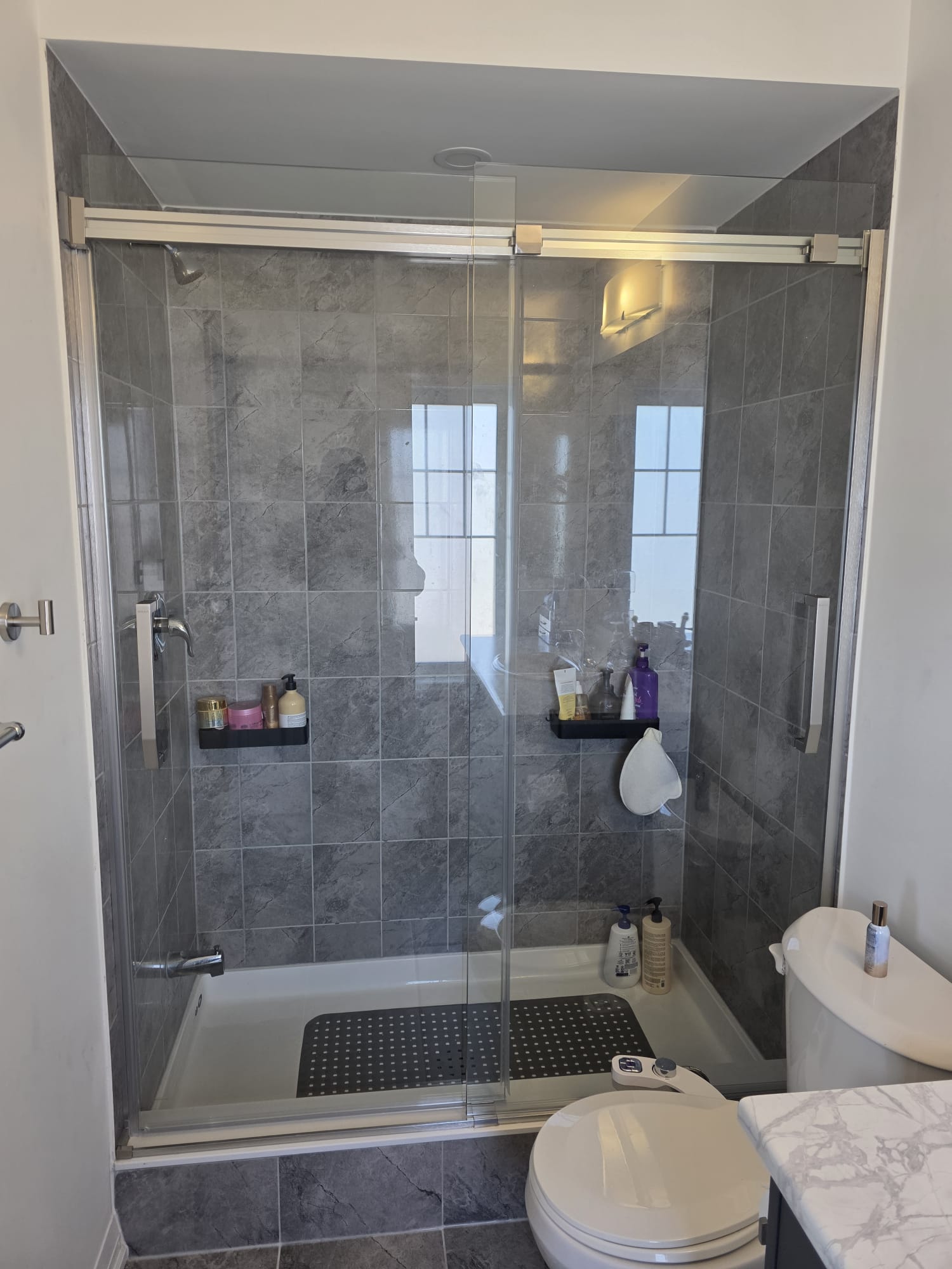 Completed custom walk-in shower conversion with modern fixtures and a seamless glass enclosure.
