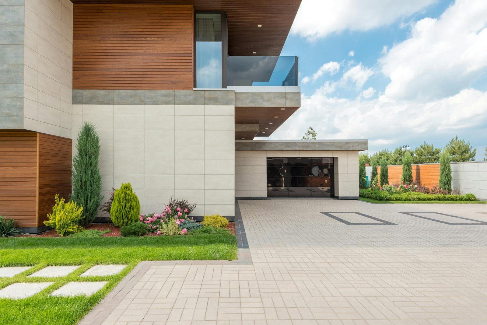 Concrete Driveway cost in Kitchener-Waterloo - A modern minimalist house with a spacious driveway, landscaped garden, and cle