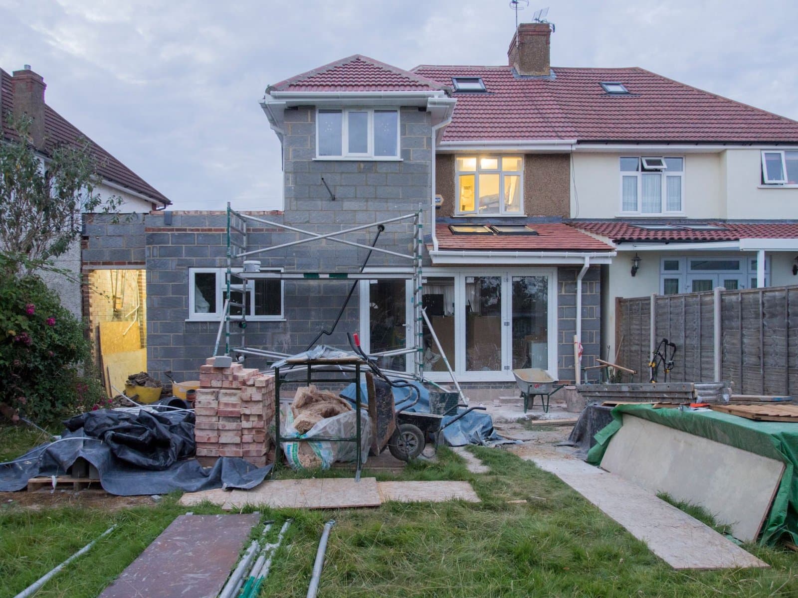 Home Addition cost in Kitchener - A suburban house undergoing major renovations with scaffolding and building materials.