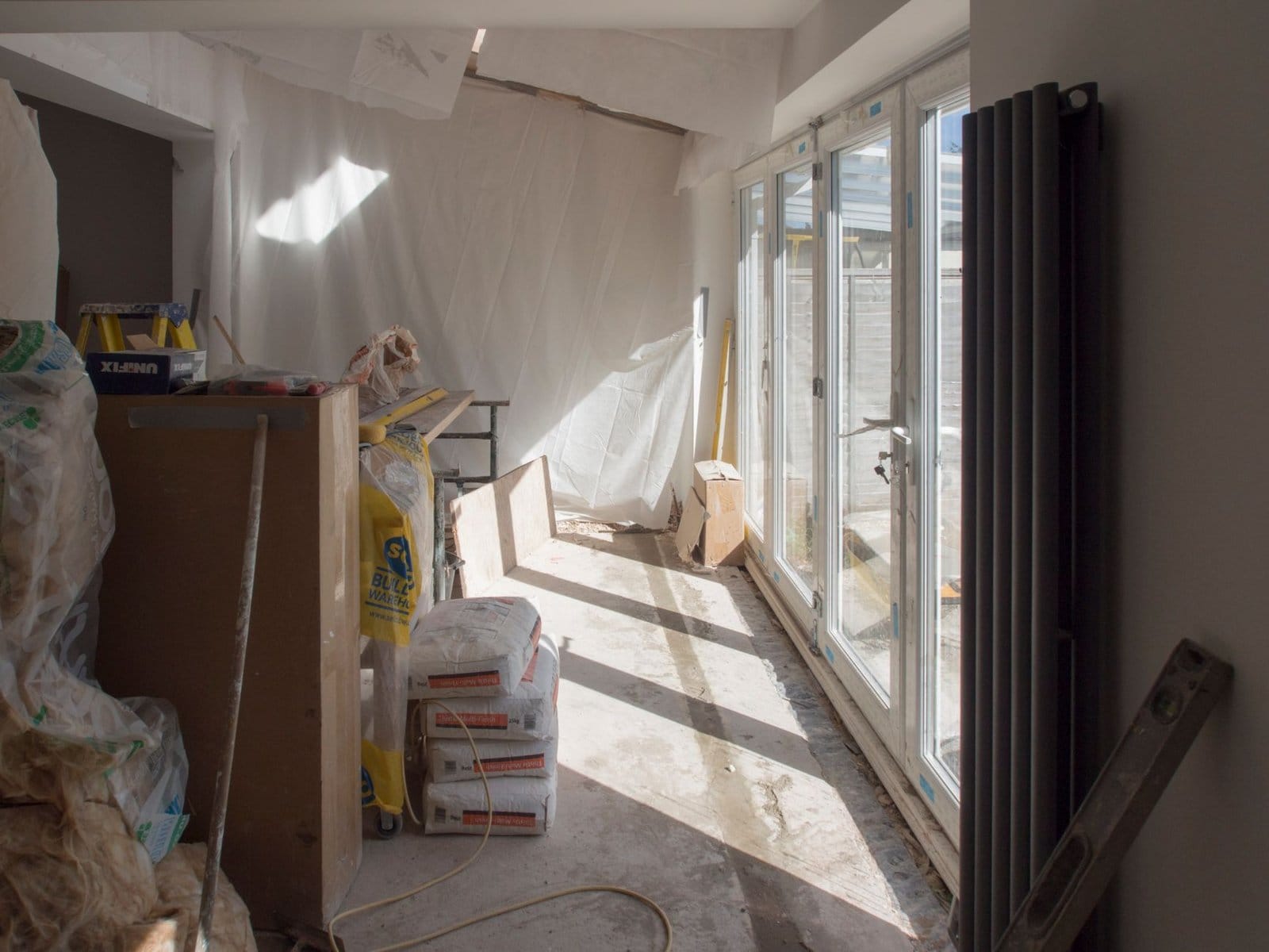 Home Addition project in Waterloo - A construction area featuring renovation work in progress with large windows bringing in