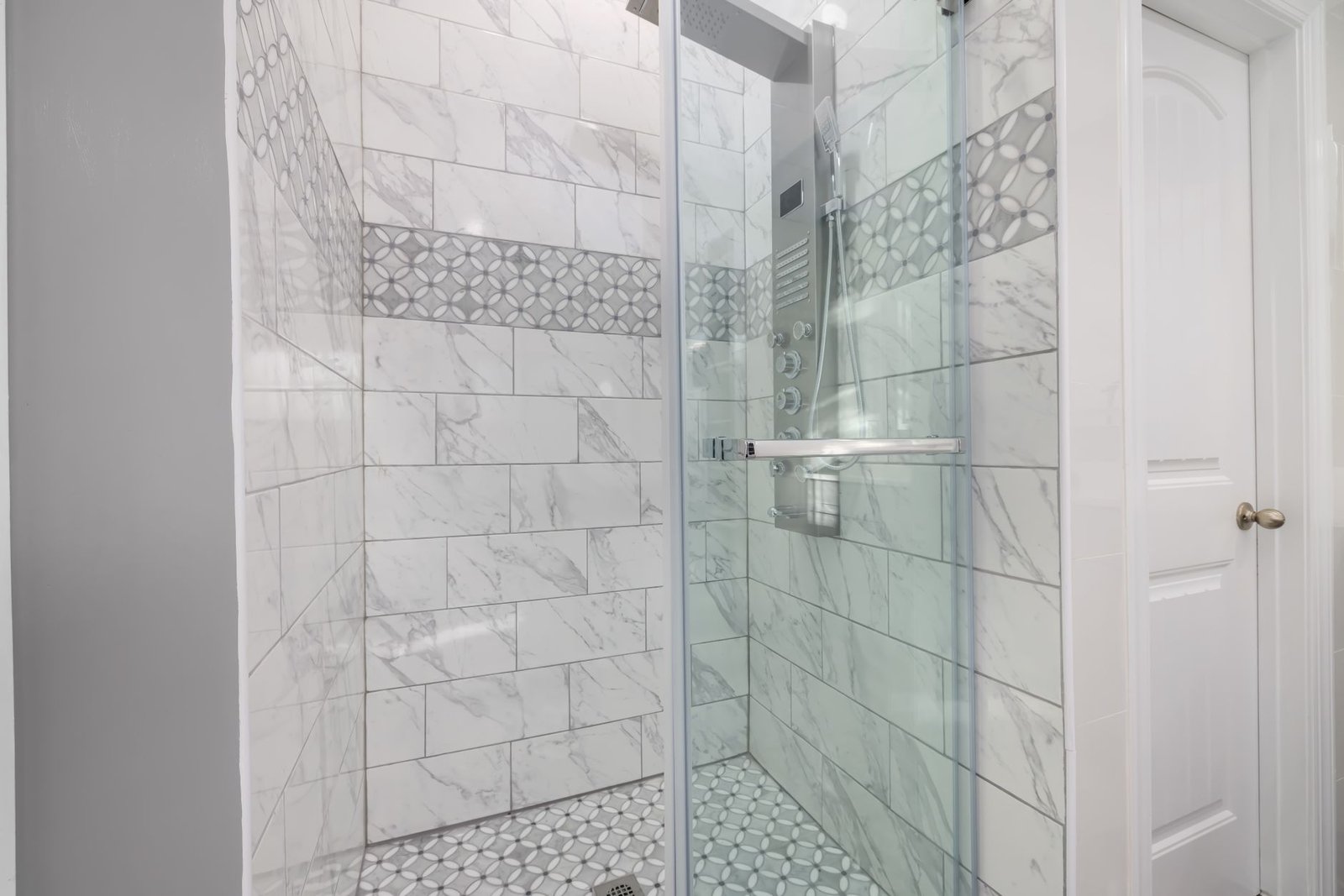 Bathroom Renovation project in Guelph - Sleek bathroom shower with marble tiles and glass door, showcasing modern interior de