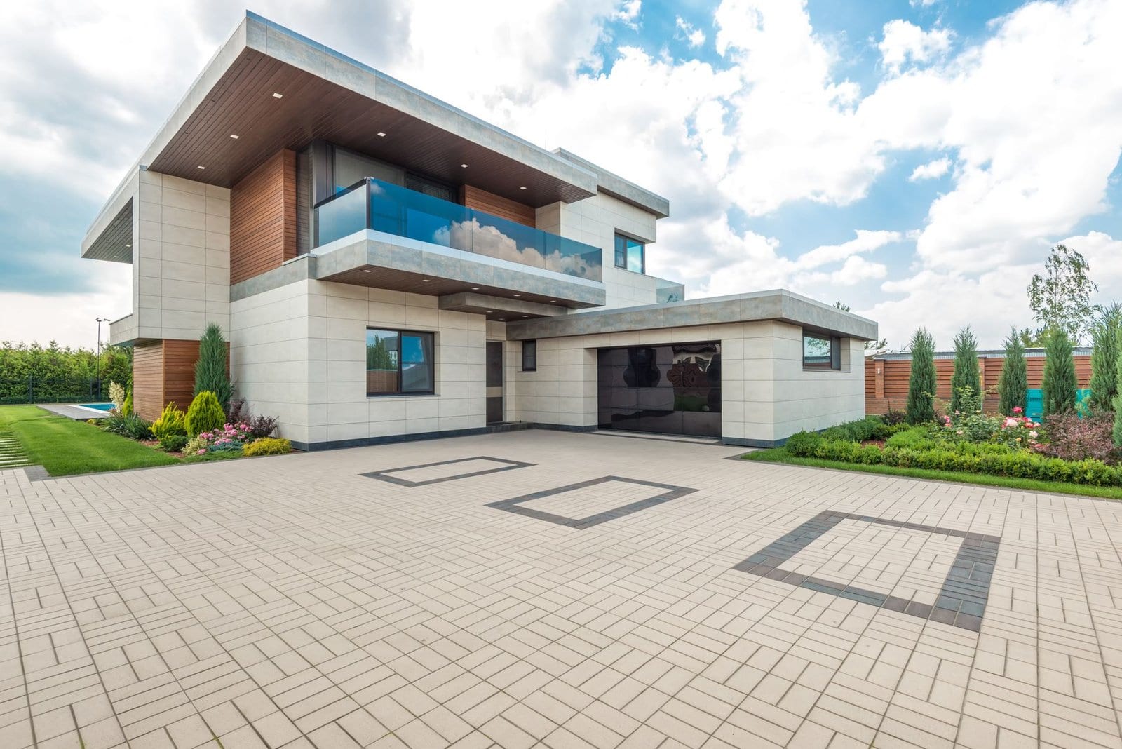 Concrete Driveway cost in Cambridge - Elegant modern house exterior with lush greenery and ample driveway space.