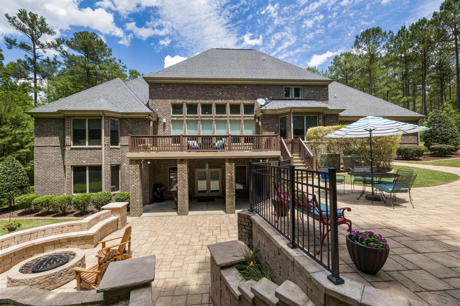 Concrete Patio project in Kitchener-Waterloo - Luxury brick house featuring a large terrace, fire pit, and well-maintained ga