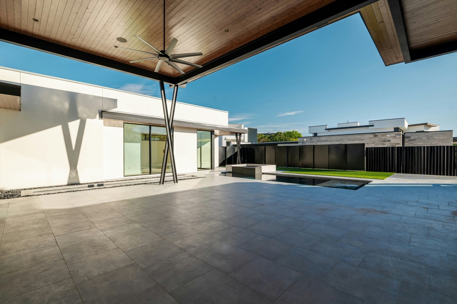 Concrete Patio cost in Kitchener-Waterloo - Modern outdoor patio with pool and contemporary architecture.
