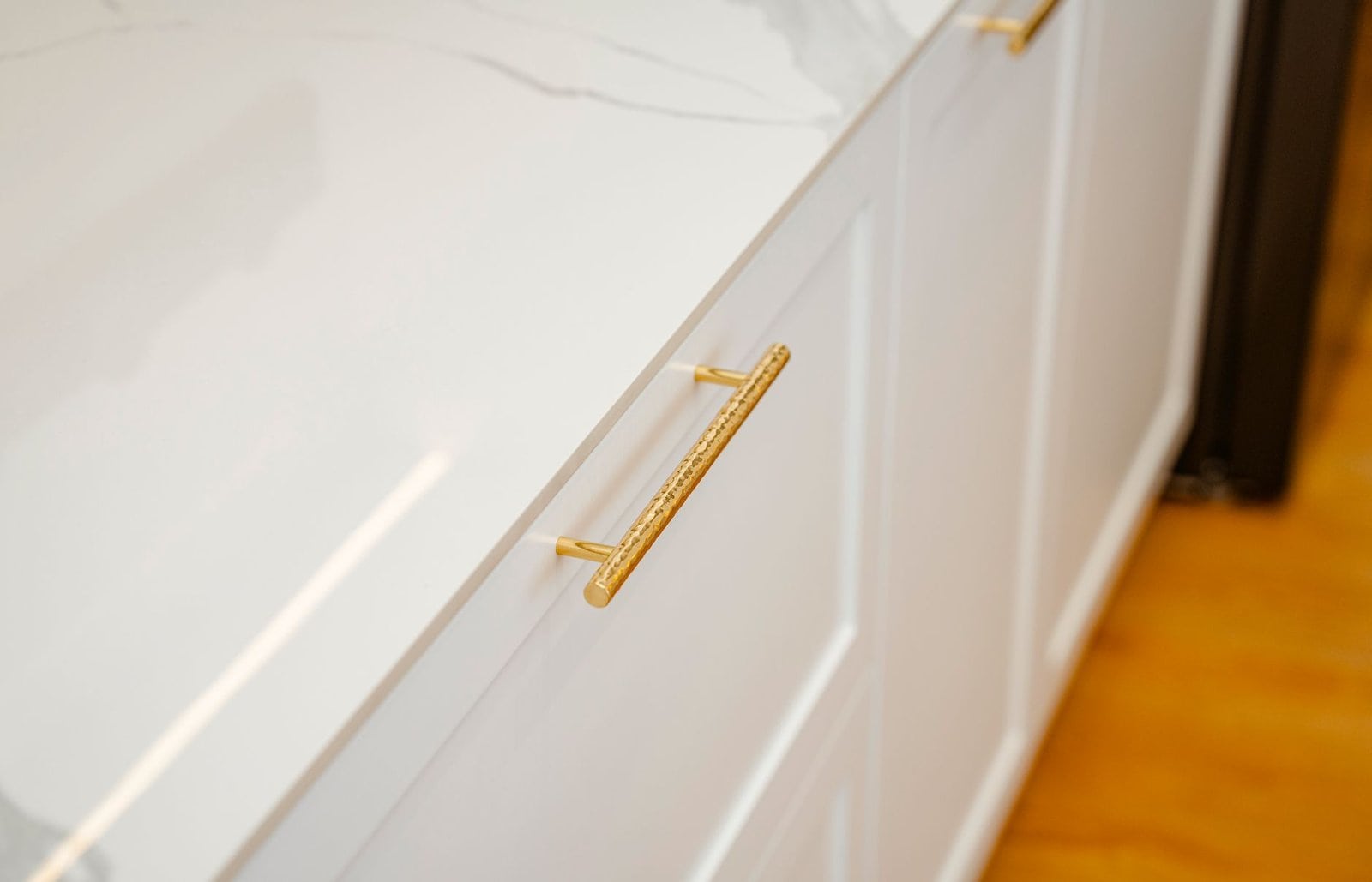 Kitchen Renovation project in Guelph - Sophisticated white cabinet with gold handles and marble top, perfect for modern inter