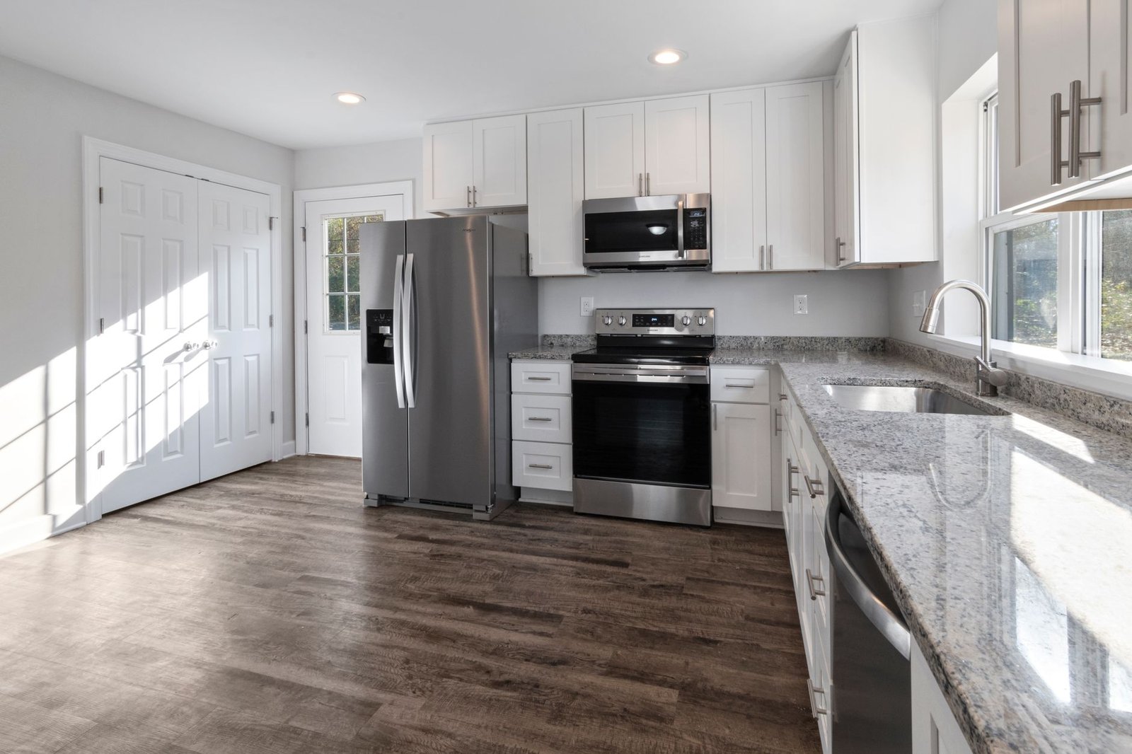 Kitchen Renovation cost in Guelph - Bright and spacious modern kitchen featuring stainless steel appliances and granite count
