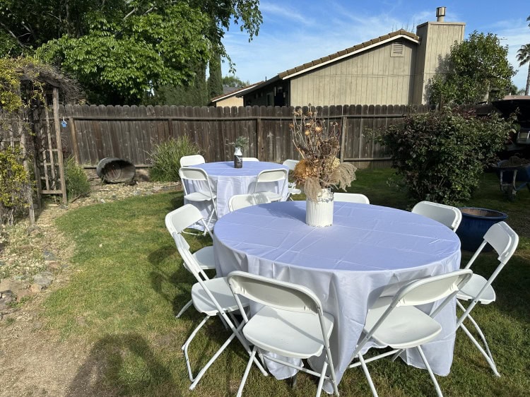 Party tables and chairs set up in a backyard