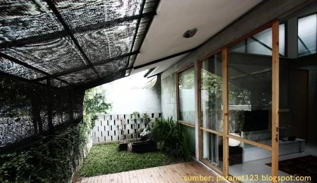 Green shading net providing shade for a home patio area Green shading net providing shade for a home patio area