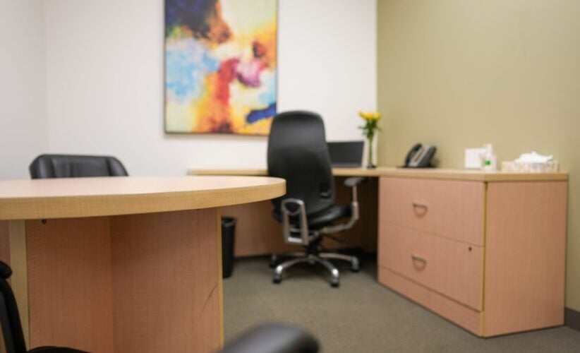 Office reception area with desk and chairs for professional business meetings.