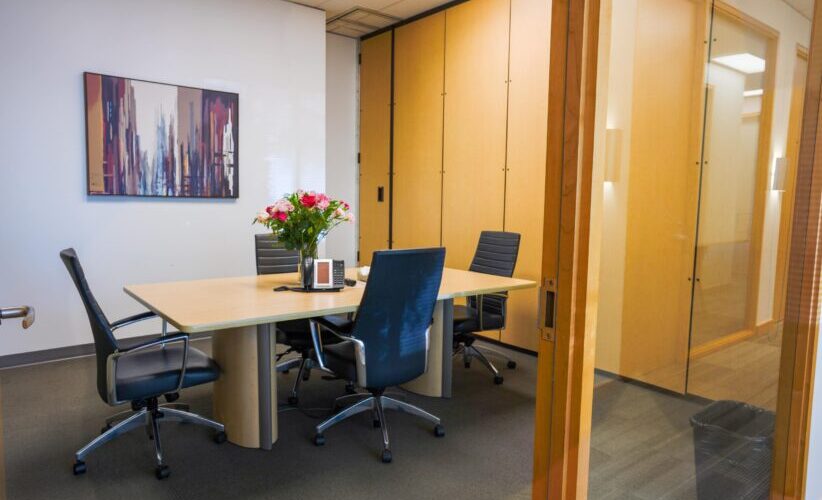 Office meeting room with modern furniture and glass walls, ideal for professional workspace settings.