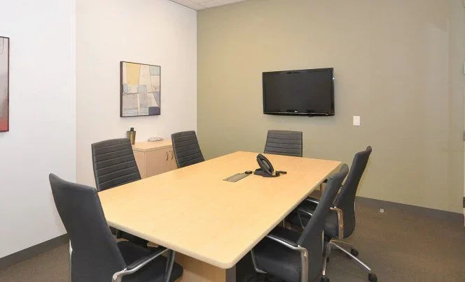 Conference room with modern furniture and teleconferencing equipment for professional meetings and business collaboration.