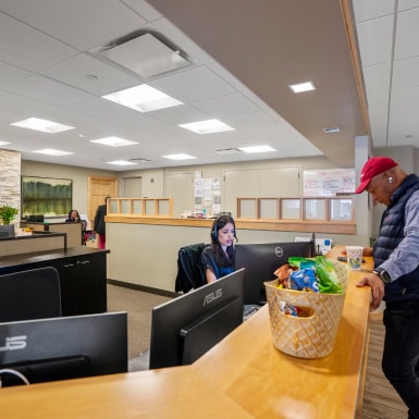 Modern office reception area with friendly staff assisting clients and vibrant workspace for franchising success.