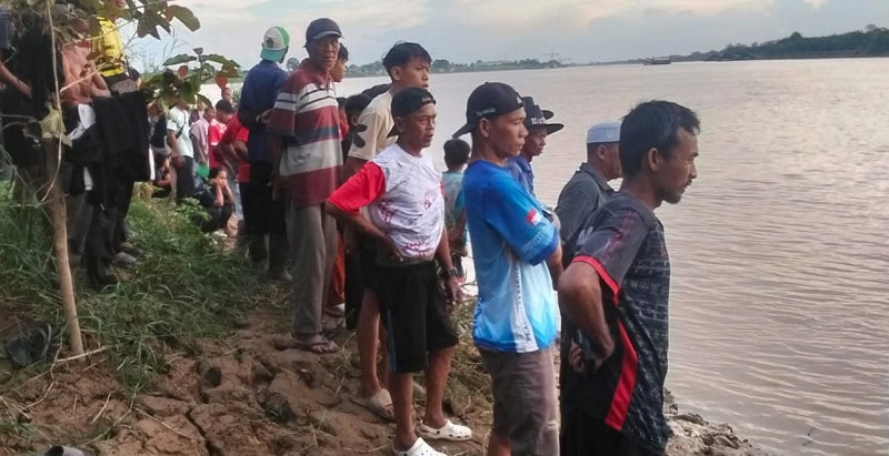 Warga menyaksikan Tim SAR Gabungan melakukan operasi pencarian seorang bocah yang hanyut di Sungai Batanghari | sar
