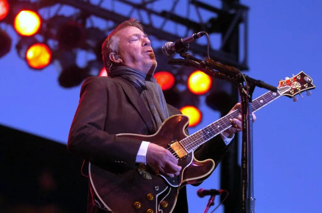 Boz Scaggs live on stage playing guitar and singing in mic