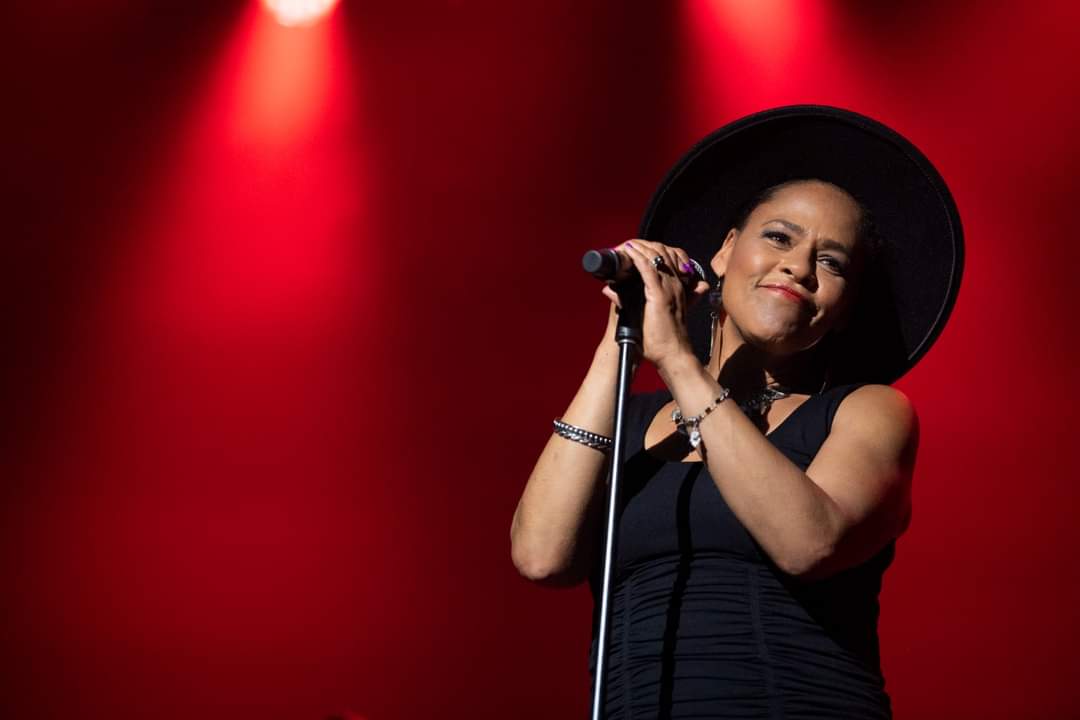 Dawn Tyler Watson at microphone on stage w/red lighting