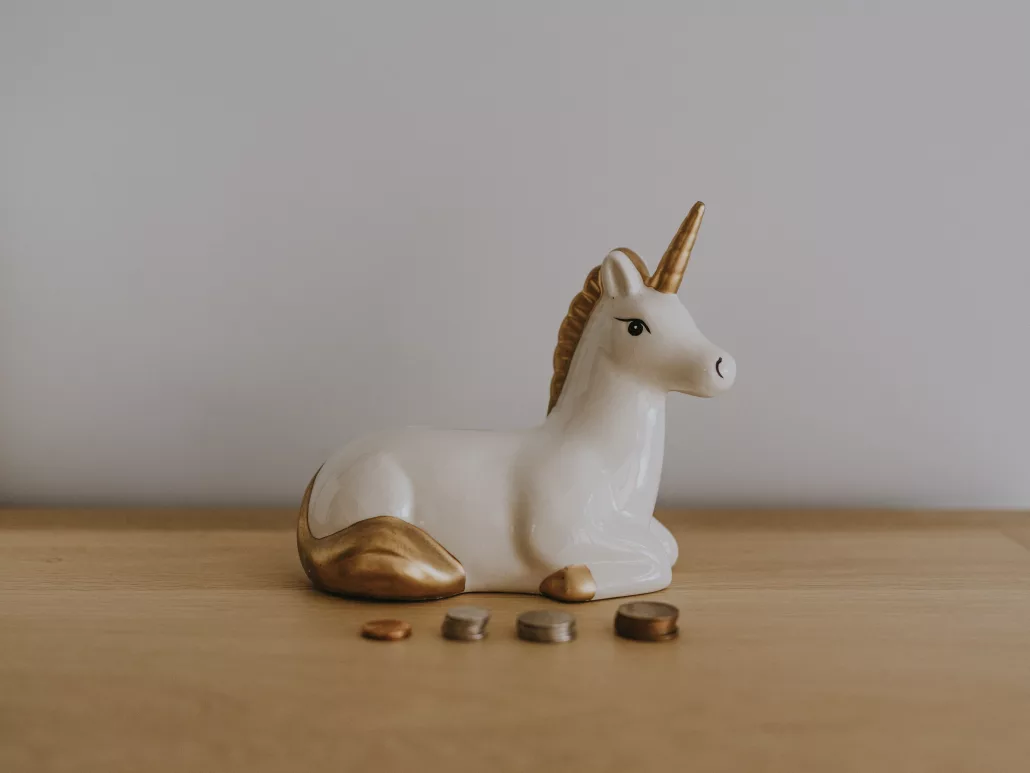 A wooden table with a ceramic unicorn.