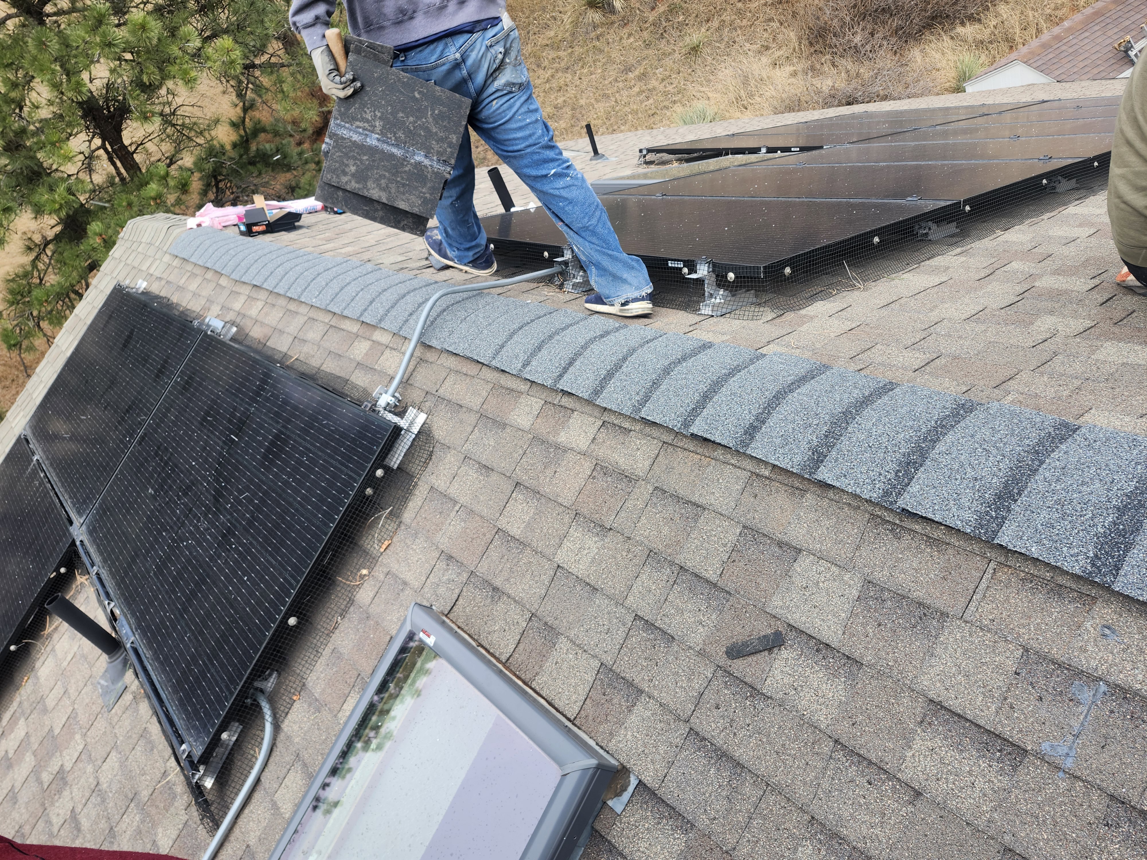 Josh pointing at decking damage and open gap in roof structure under solar array Left Hand Canyon Colorado