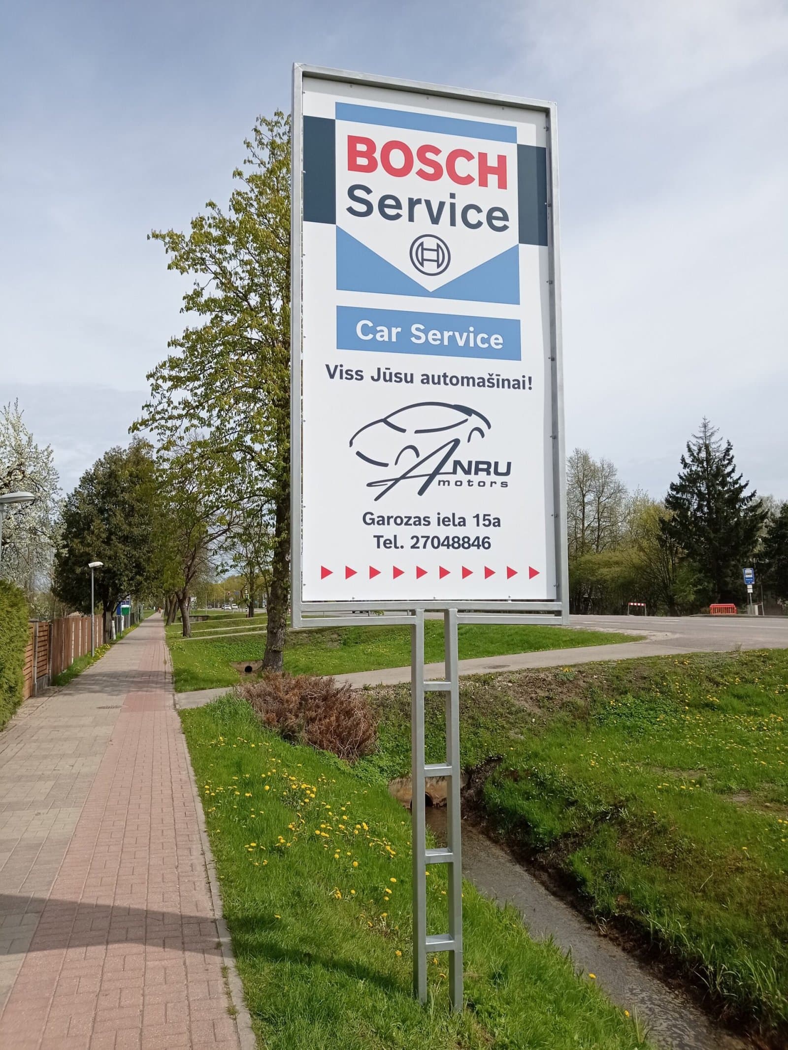 Autoservisa reklāmas stends pie ceļa