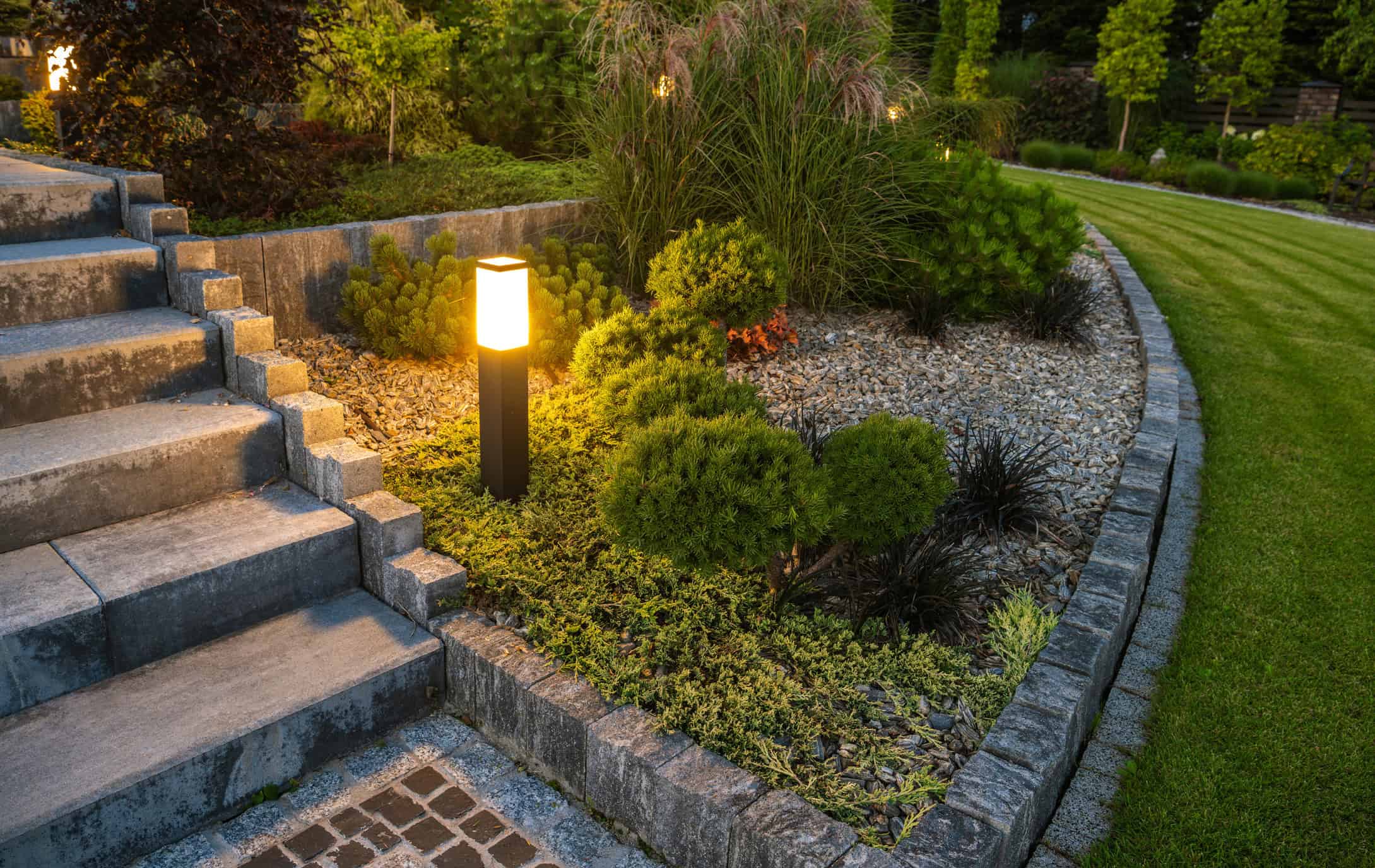 Landscape lighting on garden beds and a walkway in Fuquay Varina, NC Low-voltage landscape lighting on planting beds and a front walkway at a Willow Spring, NC home