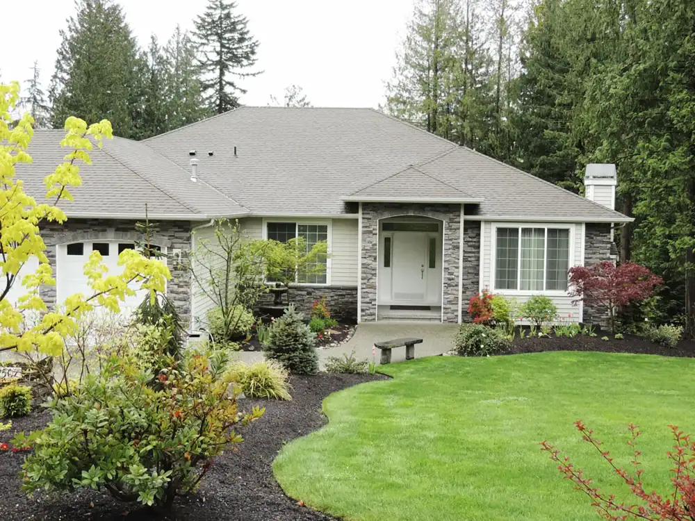 Professional shrub and landscape installation with manicured lawn and mulch beds in Apex NC