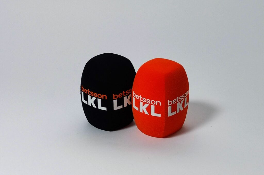 Two foam microphone windscreens in black and red with printed Betsson LKL branding, custom mic covers for broadcast and interviews.
