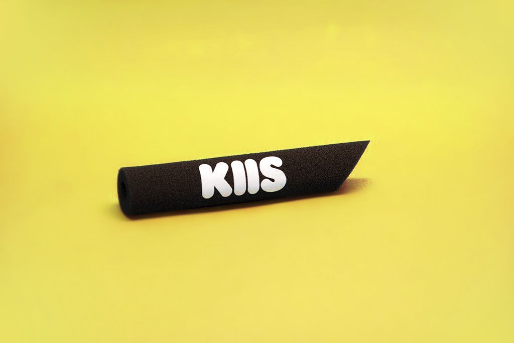 Black tapered foam microphone windscreen with “KIIS” logo on a yellow background, a branded acoustic foam cover for broadcast and studio microphones.