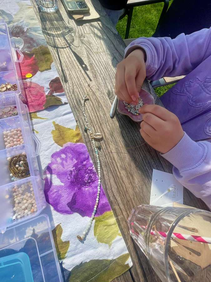 Kind fädelt Perlen auf beim Kindergeburtstag mit LIUSH Berlin
