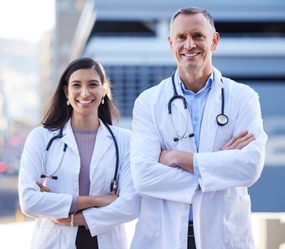 See the will of warriors. Portrait of two doctors with folded arms outside in the city