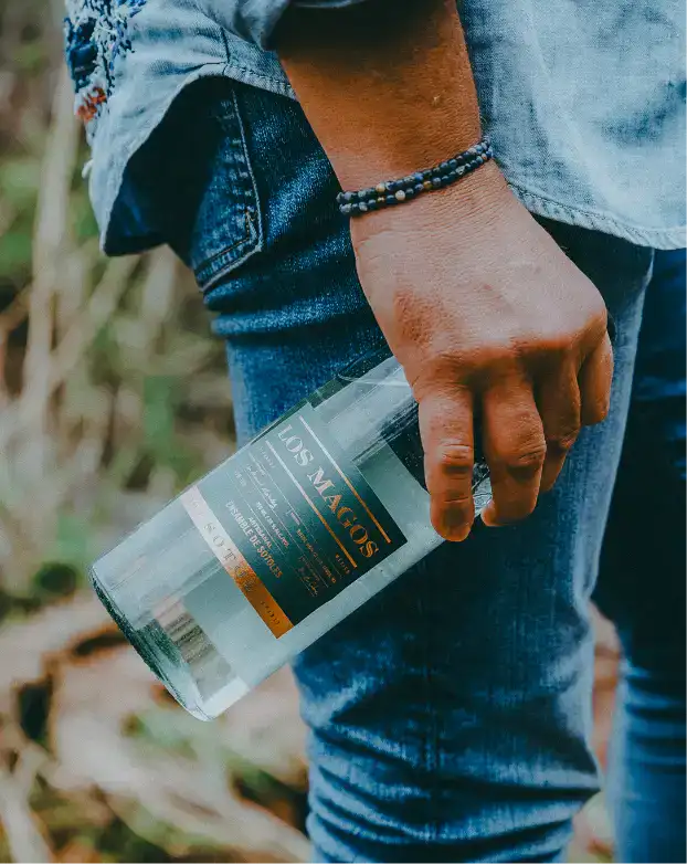 man holding los magos sotol bottle