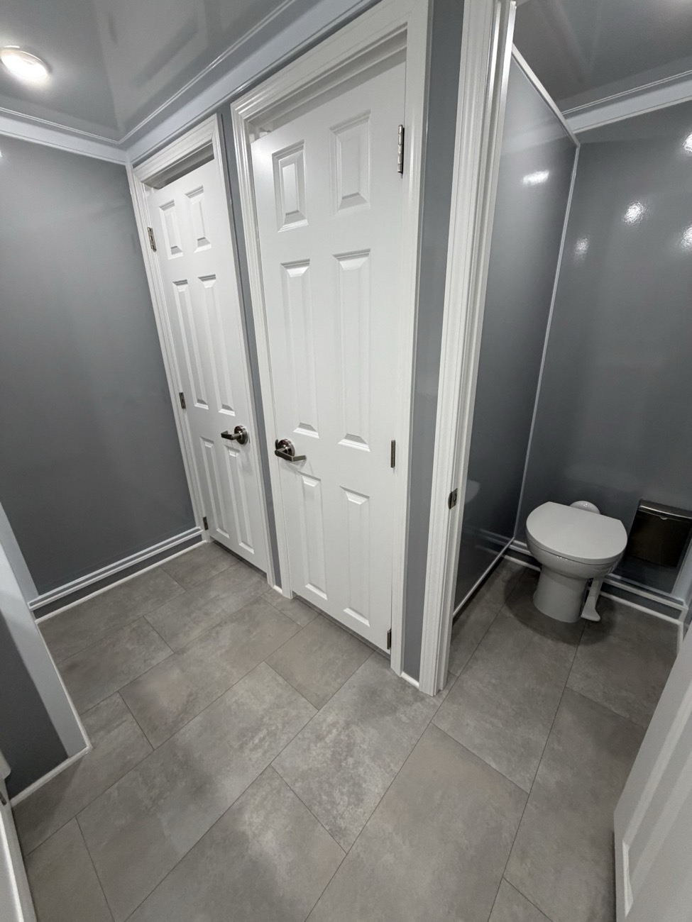 Women's private stalls inside the Lux Dumps 6-station restroom trailer