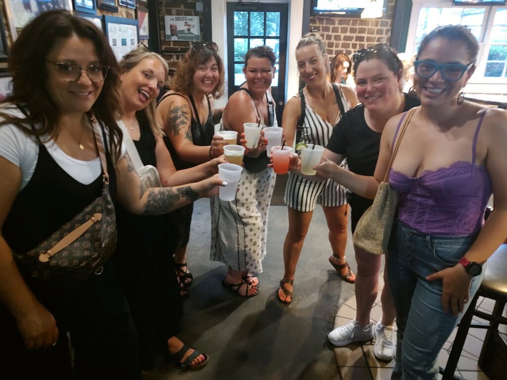 Group of friends enjoying drinks together on a mad cat pub crawl