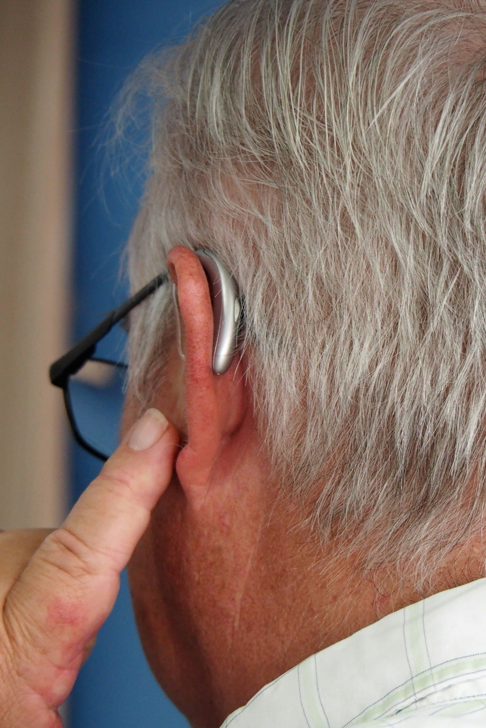 Homme senior portant une aide auditive