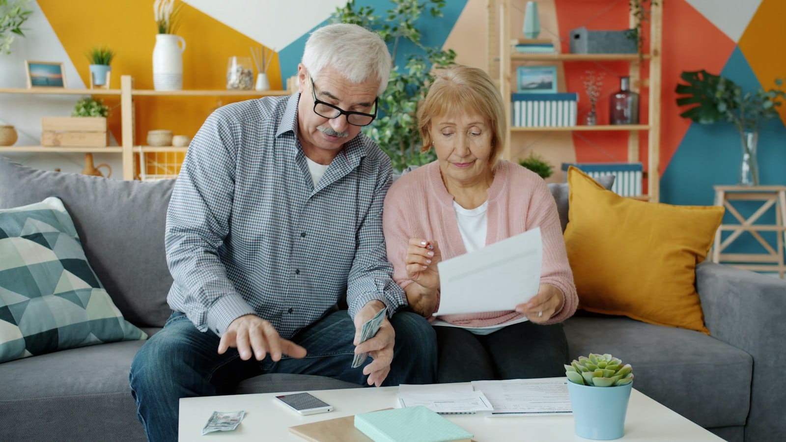 Couple de seniors examinant des documents d’assurance à leur domicile