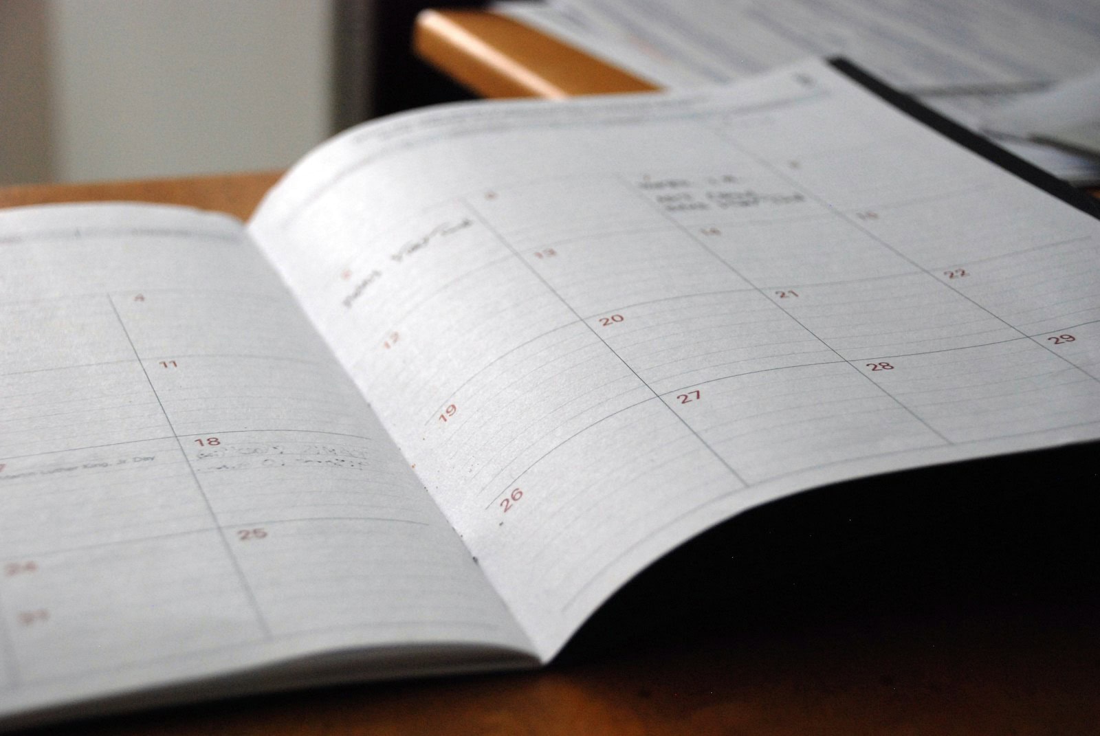 Calendrier mensuel ouvert sur un bureau en bois