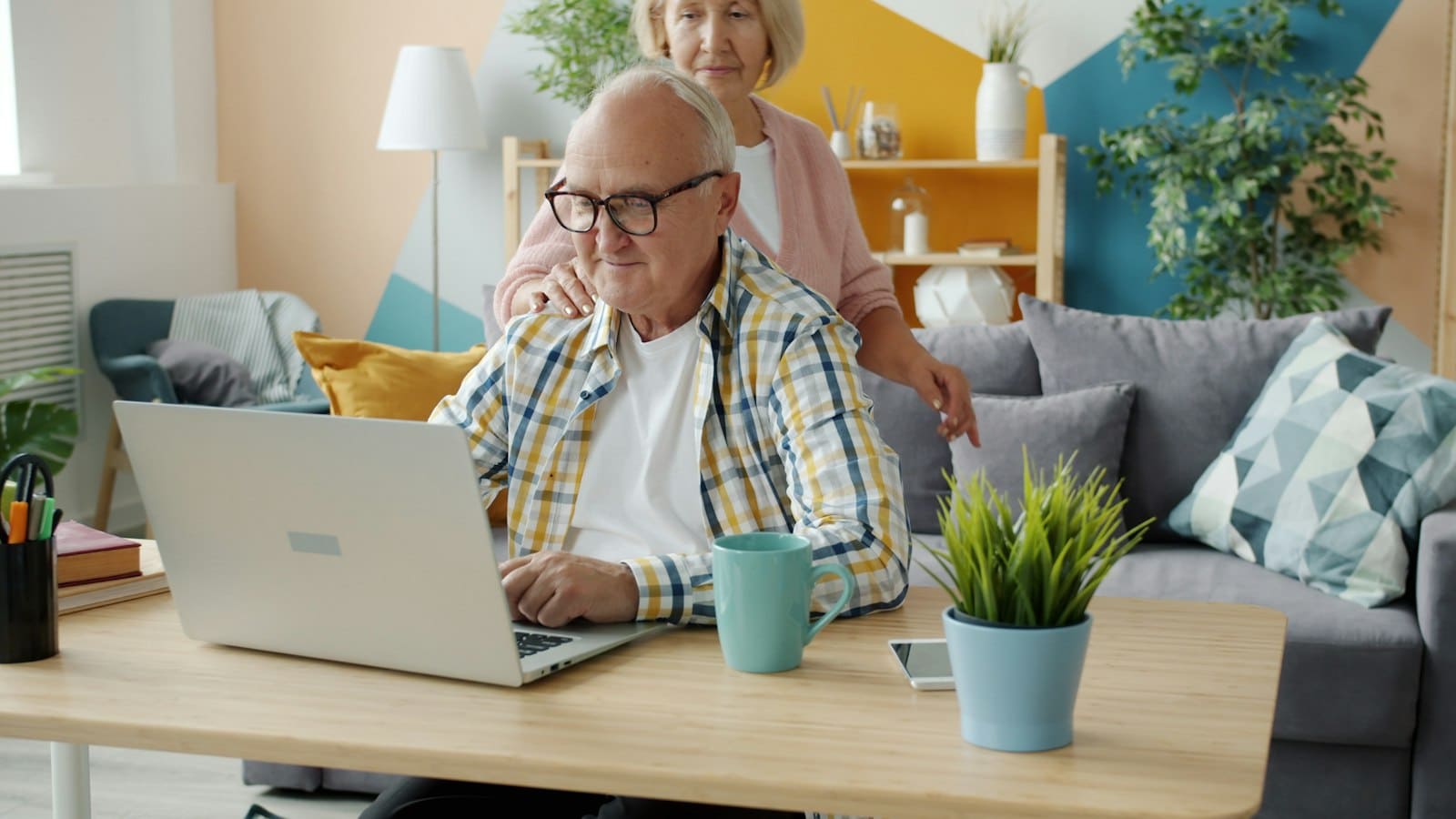 Couple de seniors comparant des offres de mutuelle sur un ordinateur portable
