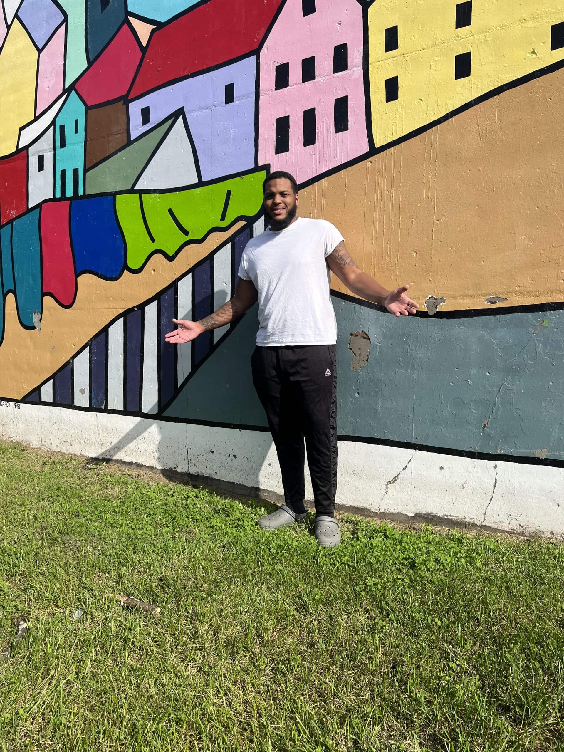 IMG-5893 man standing in front of a colorful mural