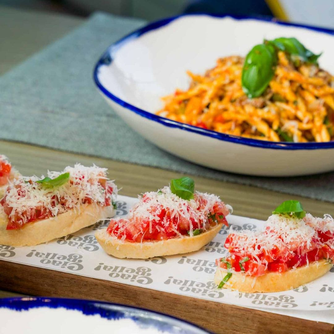 Fresh bruschetta with tomato and basil served alongside flavorful pasta at Ciao Bella, offering authentic Italian cuisine.