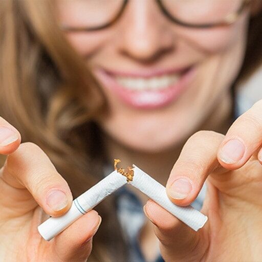 Women breaking cigarette in half