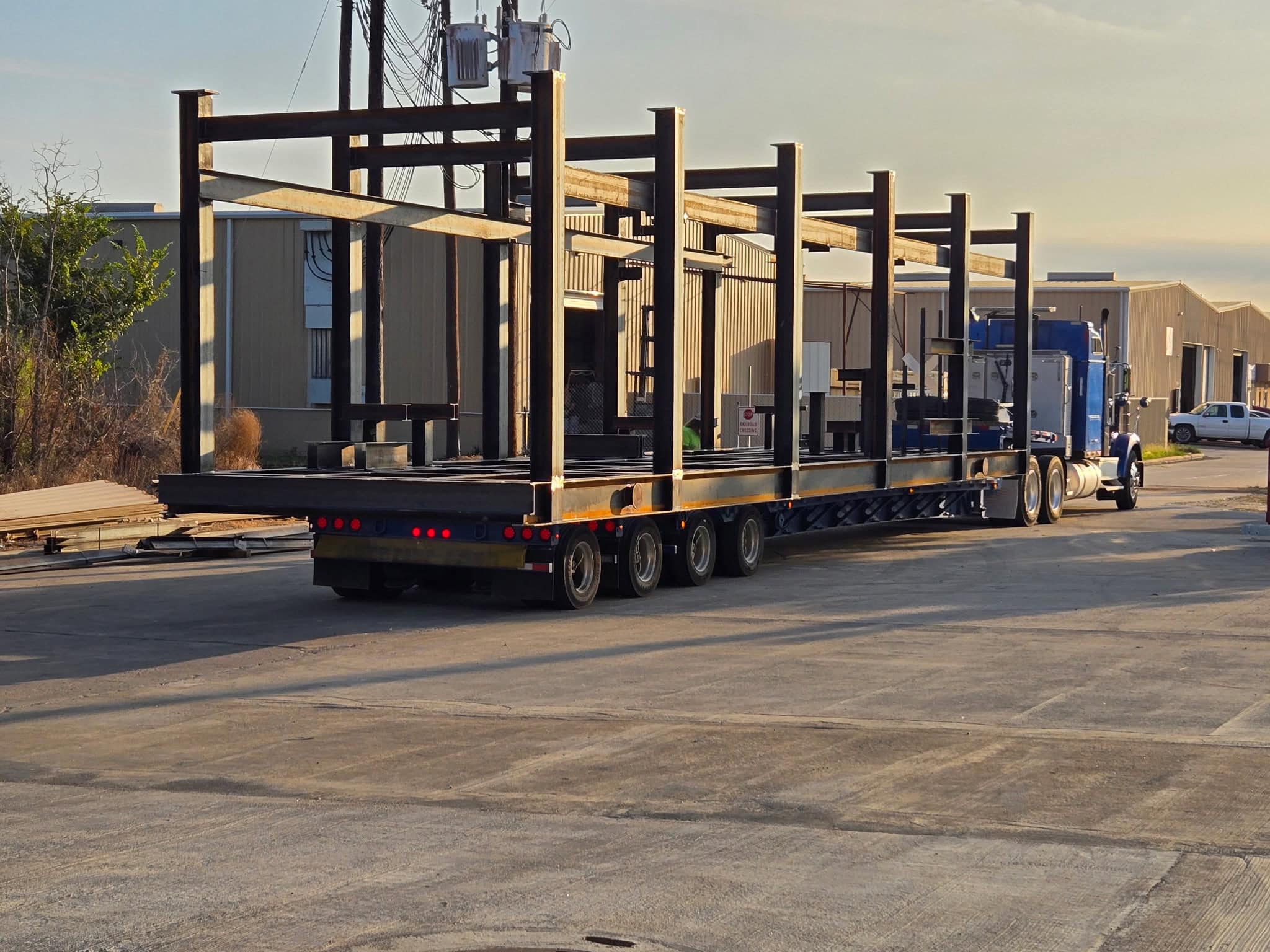 Two large structural steel skid structures loaded on a multi-axle flatbed trailer for transport from the WeldIT shop