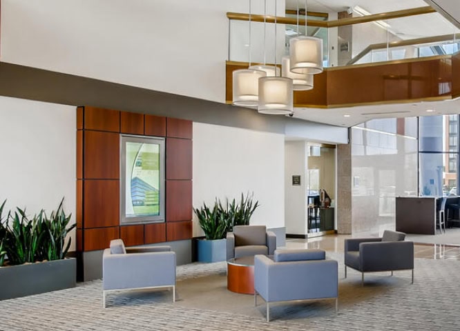 Office Evolution franchising interior with modern waiting area, comfortable chairs, and contemporary decor, highlighting opportunities in flexible professional workspace solutions.