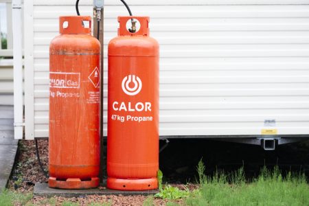 Porthcawl, Bridgend / Wales, UK - July 21st 2019: Calor gas cylinder bottles in cage fence at caravan park site