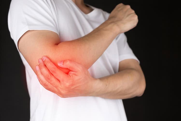 Person clutching painful elbow with visible inflammation area - One Body LDN Person clutching painful elbow with visible inflammation area