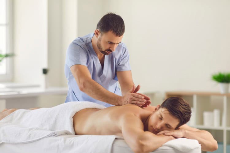 Therapist applying deep tissue massage technique in calm setting - One Body LDN Therapist applying deep tissue massage technique in calm setting