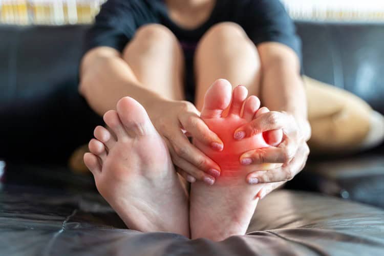 What is Foot Pain - One Body LDN Person holding foot in pain from plantar fasciitis