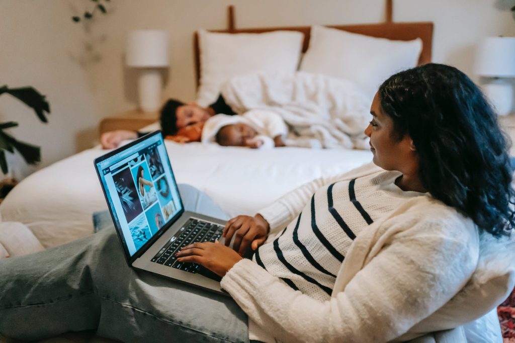 A woman works on her laptop whilst others sleep